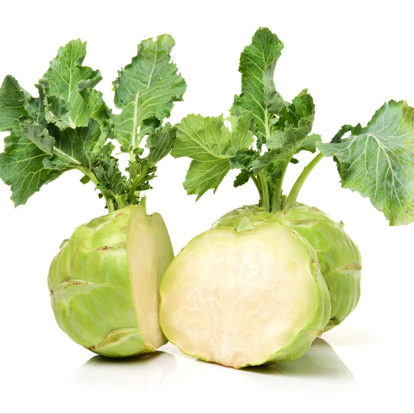 to green early white Vienna kohlrabi with one cut in half displaying its light insides with green leafy stems against a white background