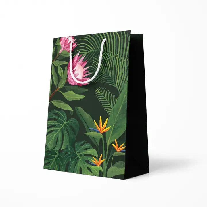 Gift bag with tropical leaf and flower design on a white background