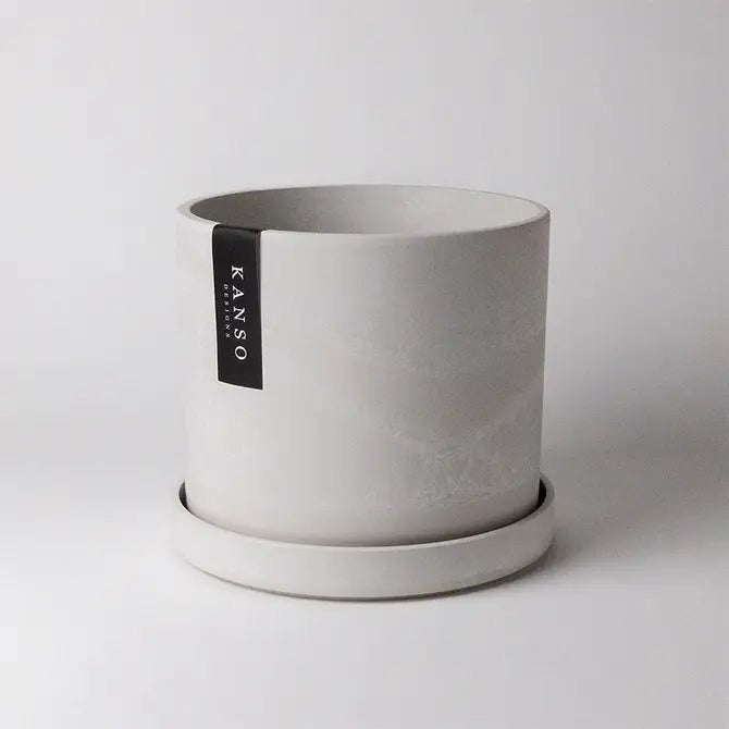 White stone planter with a Kanso Designs label on a light gray background