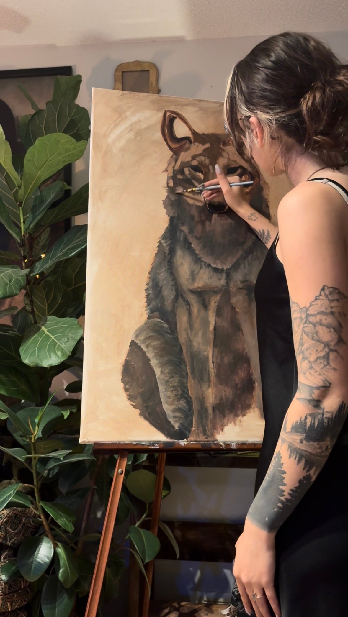 Person painting a wolf on an easel in a studio setting
