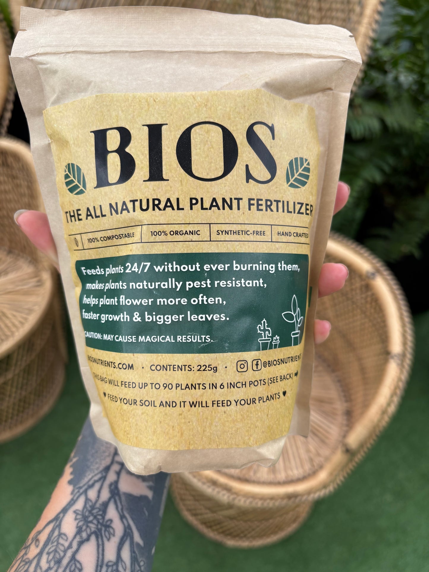 Bag of BIOS plant fertilizer held by a person with a blurred background
