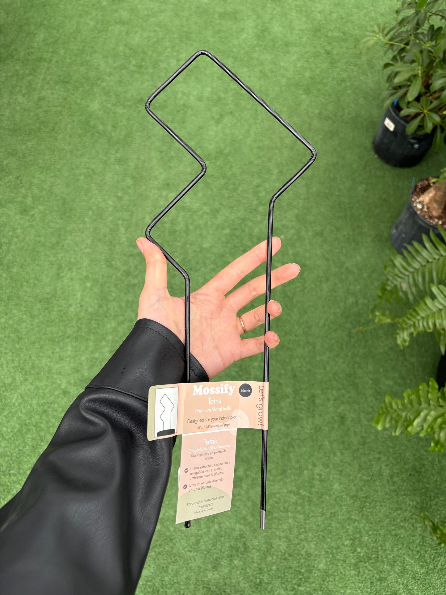 a person holding "Tetris" Metal Trellis against green background