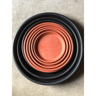 Stack of black plastic pot saucers in varying sizes, with a terracotta color inner saucer visible at the top.