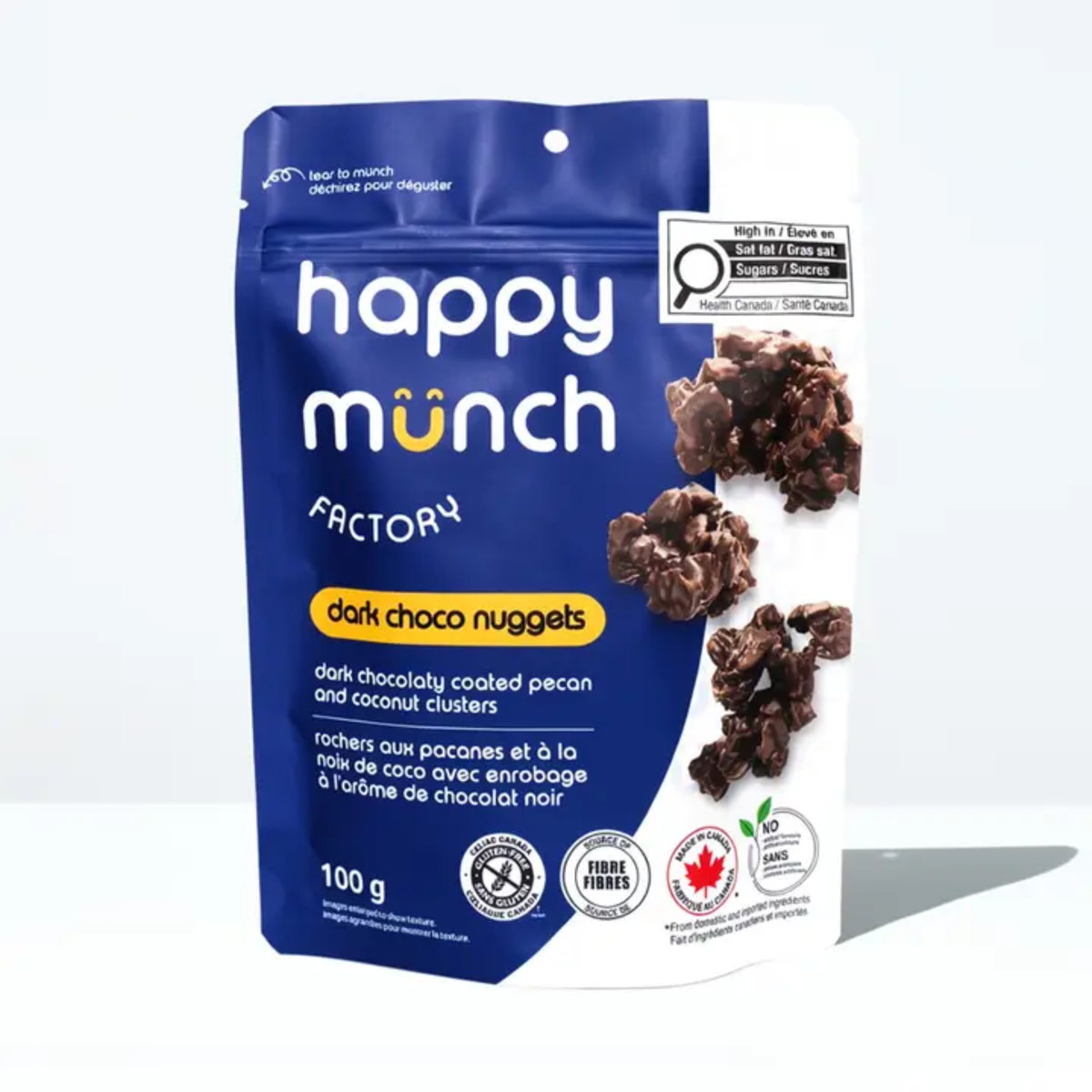 a blue package of happy munch factory dark chocolate nuggets with images of chocolate covered pecan clusters with a white background
