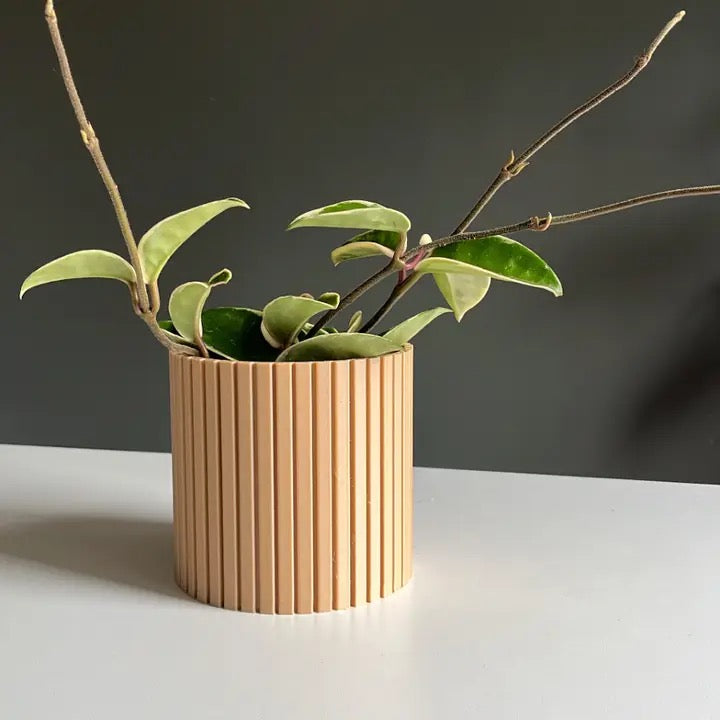 a tan coloured nordic style pot resting on a white surface