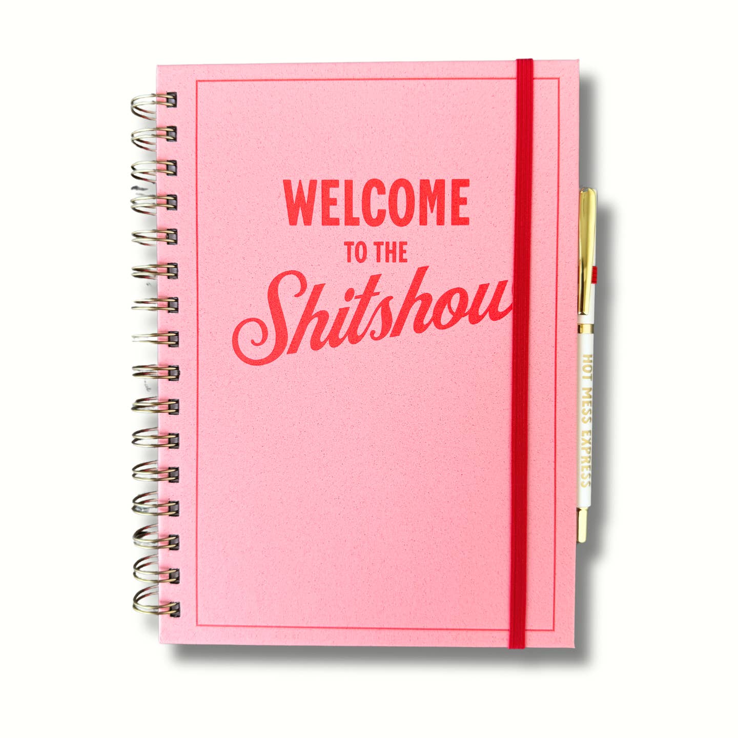 A pink notebook with the phrase 'Welcome to the Shit Show' printed in bold, red script.