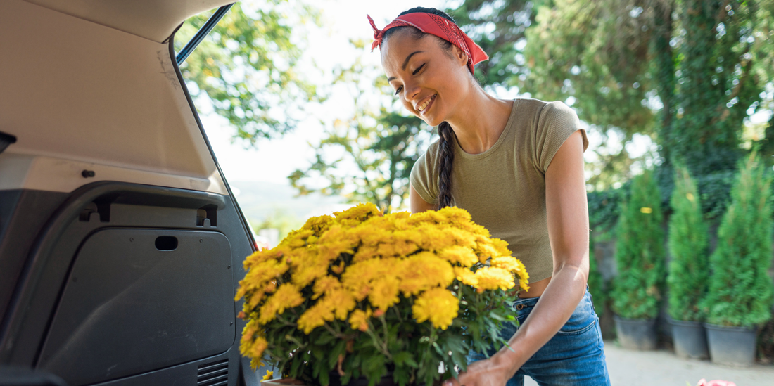 woman putting a box of flowers in a vehicle