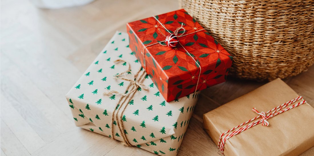 three Christmas gifts and a wicker basket on a wooden floor