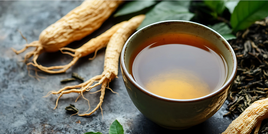 a cup of tea surrounded by ginger roots and greenery on a grey surface