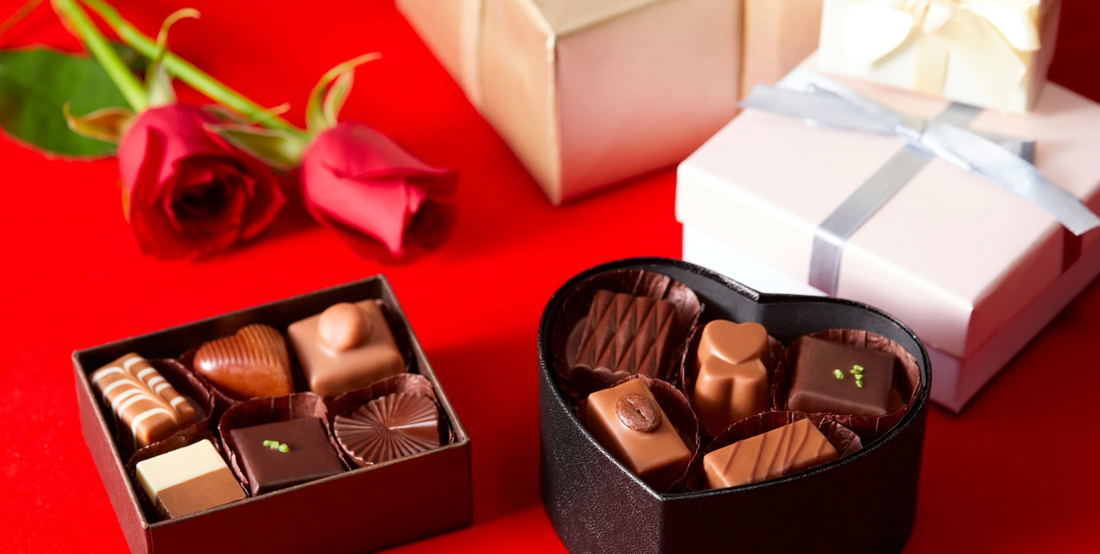 boxes of chocolate, red roses and neatly wrapped gifts resting on a bright red surface