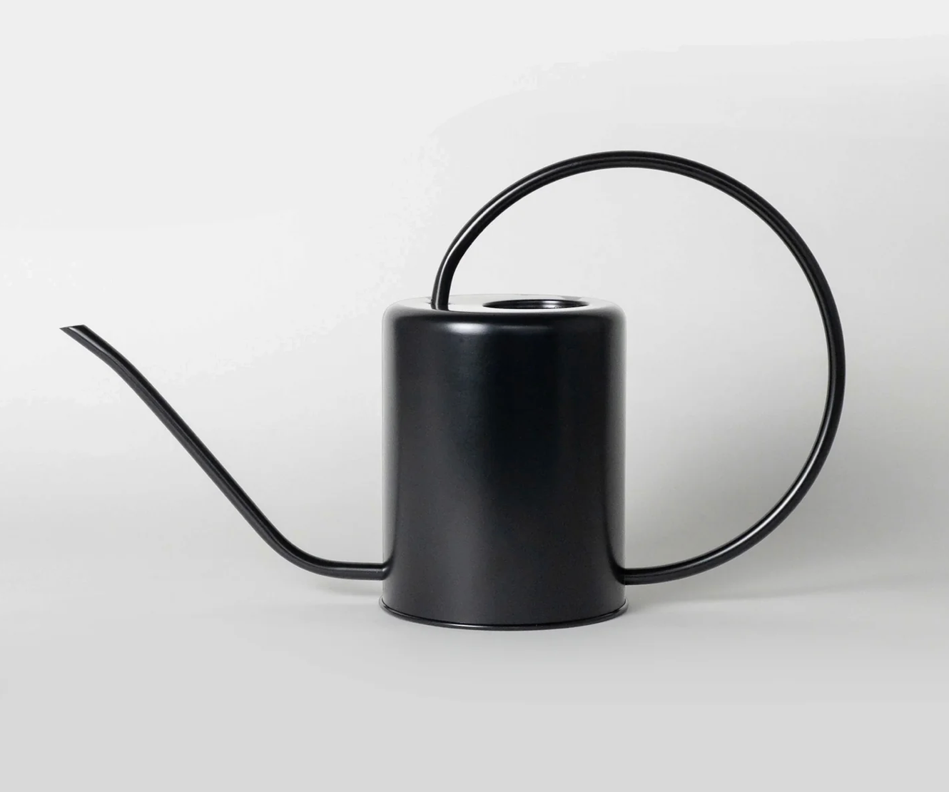 a stainless steel black watering can with a plain background
