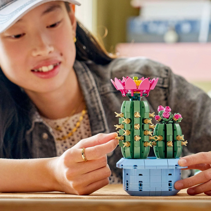 LEGO Botanicals Flowering Cactus 11509 building set being built by a young girl with a blurred background