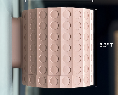 a pink wall mounted planter showing that it is 5.3" high on a light grey wall with dark background