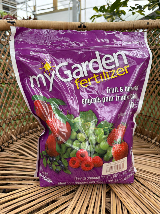 Purple bag of myGarden fertilizer with fruit and vegetable imagery on a woven surface.
