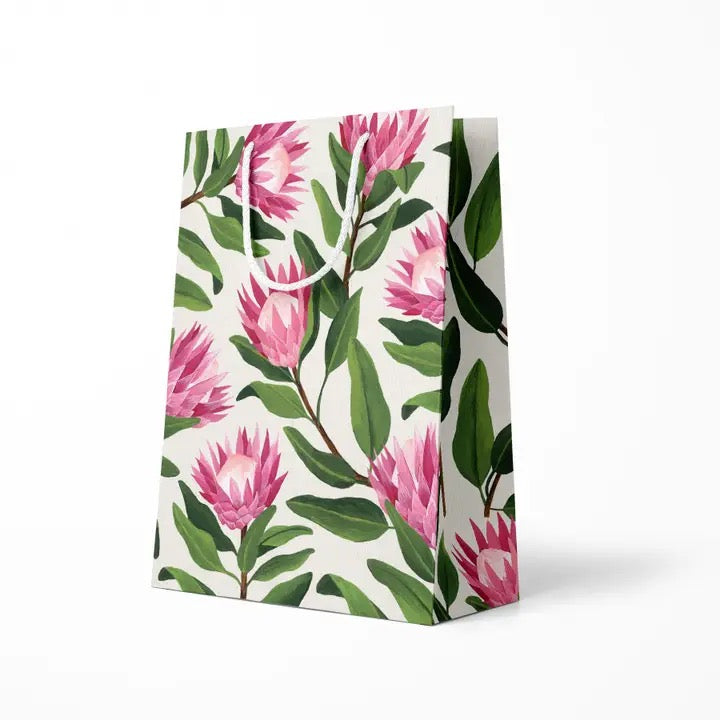 Floral-patterned paper bag with pink flowers and green leaves on a white background