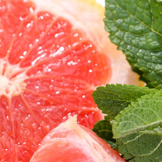 bright pink ruby grapefruit cut open next to mint leaves