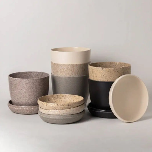 Set of recycled pots and bowls in various sizes on a light gray background