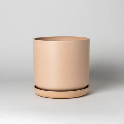 Coral recycled material planter on a light gray background