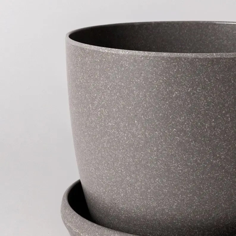 Close-up of a gray textured pot on a light gray background