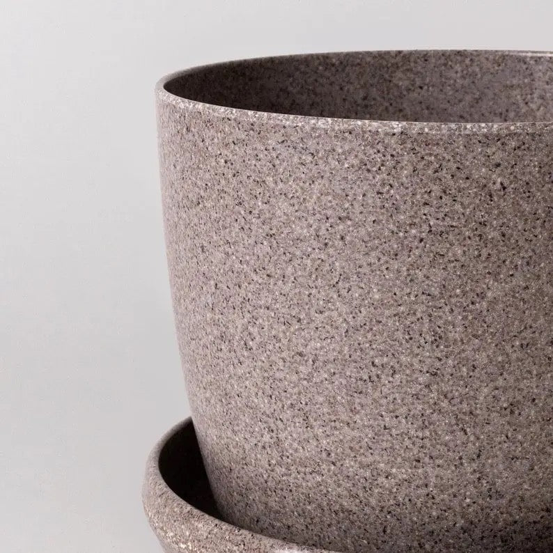 Close-up of a textured gray pot on a light gray background