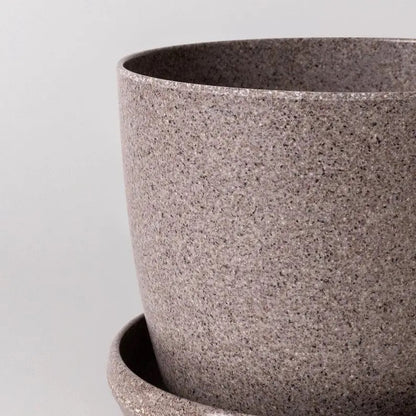 Close-up of a textured gray pot on a light gray background