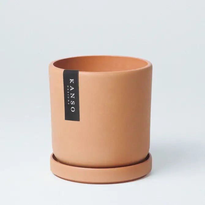 Terracotta-colored plant pot with 'KANSO' Designs label on a light gray background
