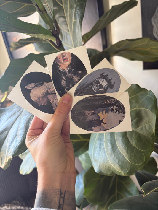 Hand holding a sheet of oval-shaped stickers with artistic designs, in front of a plant.
