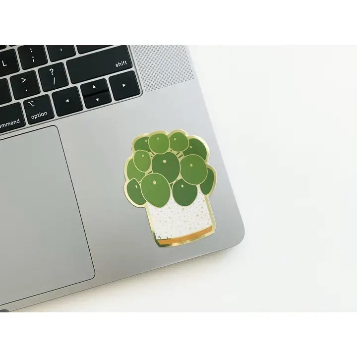 Laptop with a green potted plant sticker on a white surface