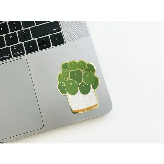 Laptop with a green potted plant sticker on a white surface
