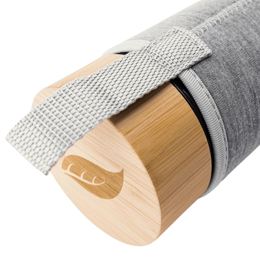 close up of the tease glass tumbler with a wooden lid inn a grey sleeve against a white background