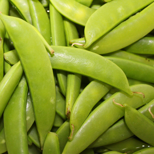 a close up of a large pile of bright green sugar snap peas
