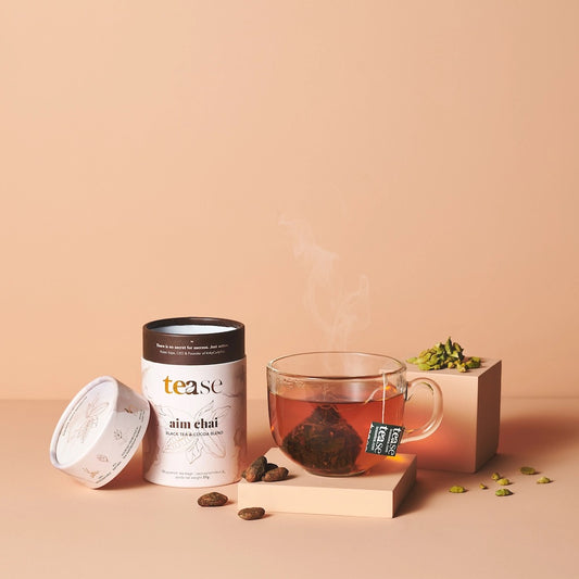 Tea packaging and cup with tea leaves on a beige background