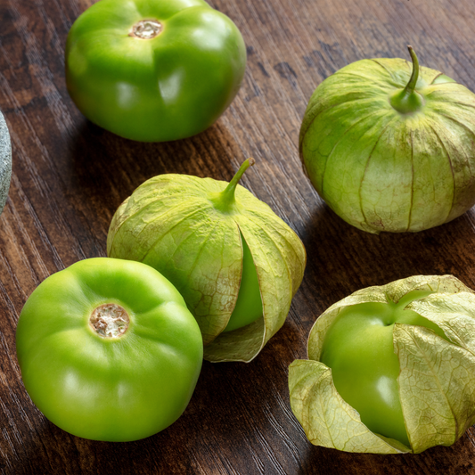 five tomatillo grand rio verde green tomatoes on a wooden surface