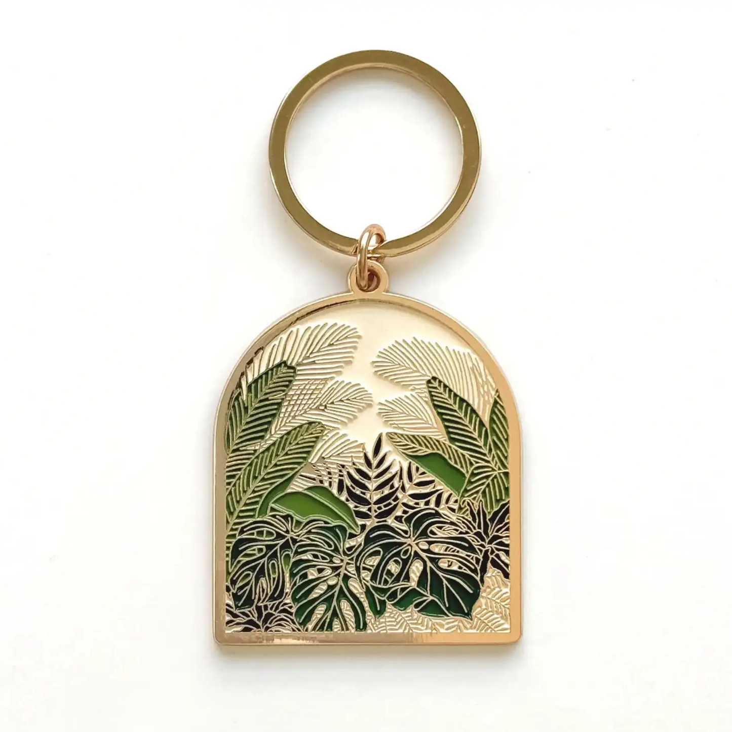 A gold-tone metal keychain featuring an arched pendant with an intricate tropical leaf design in dark green and gold-tone metal.