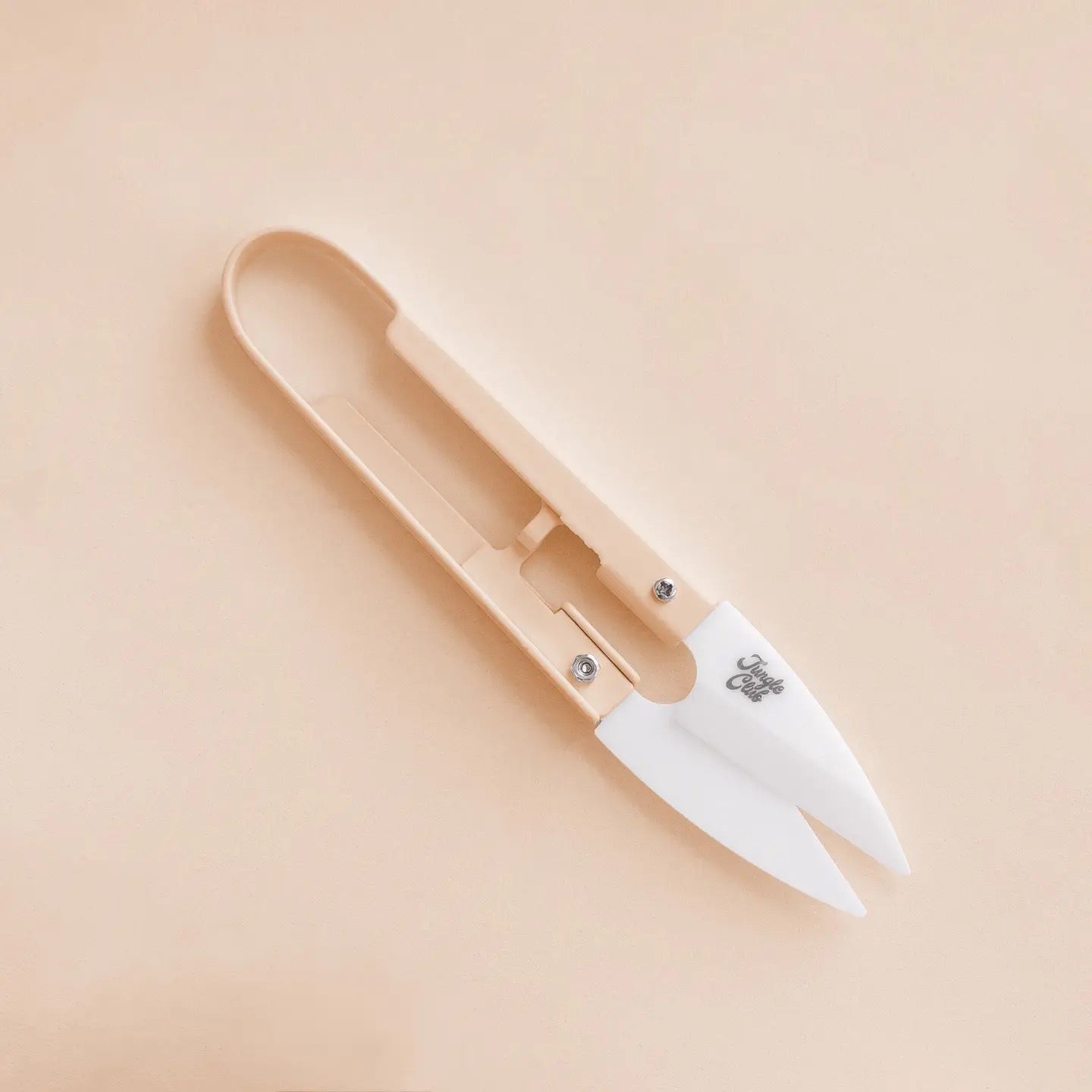 a pair of beige plant snips against a beige background