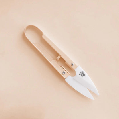 a pair of beige plant snips against a beige background