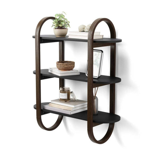 A wall-mounted shelving unit with a sleek, pill-shaped frame consisting of three tiers, with various decorative items displayed on it.