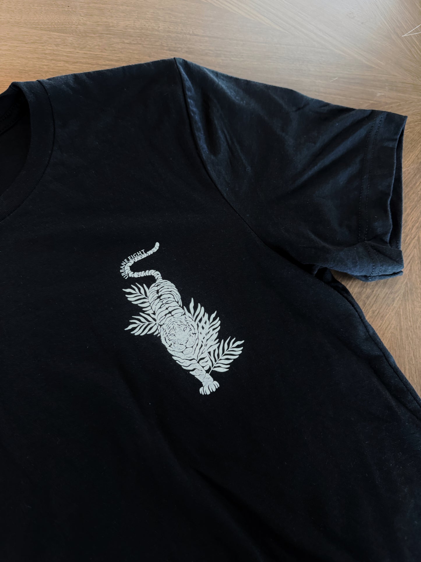 a close up of a black t-shirt with a white tiger on the front