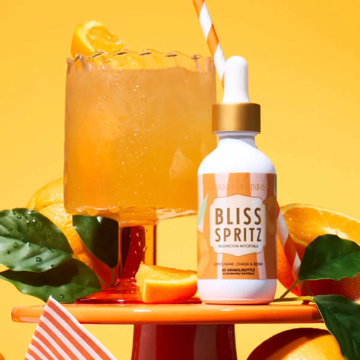 a white dropper bottle with an orange label that says bliss sprit mushroom mocktail next to an orange cocktail with an orange background