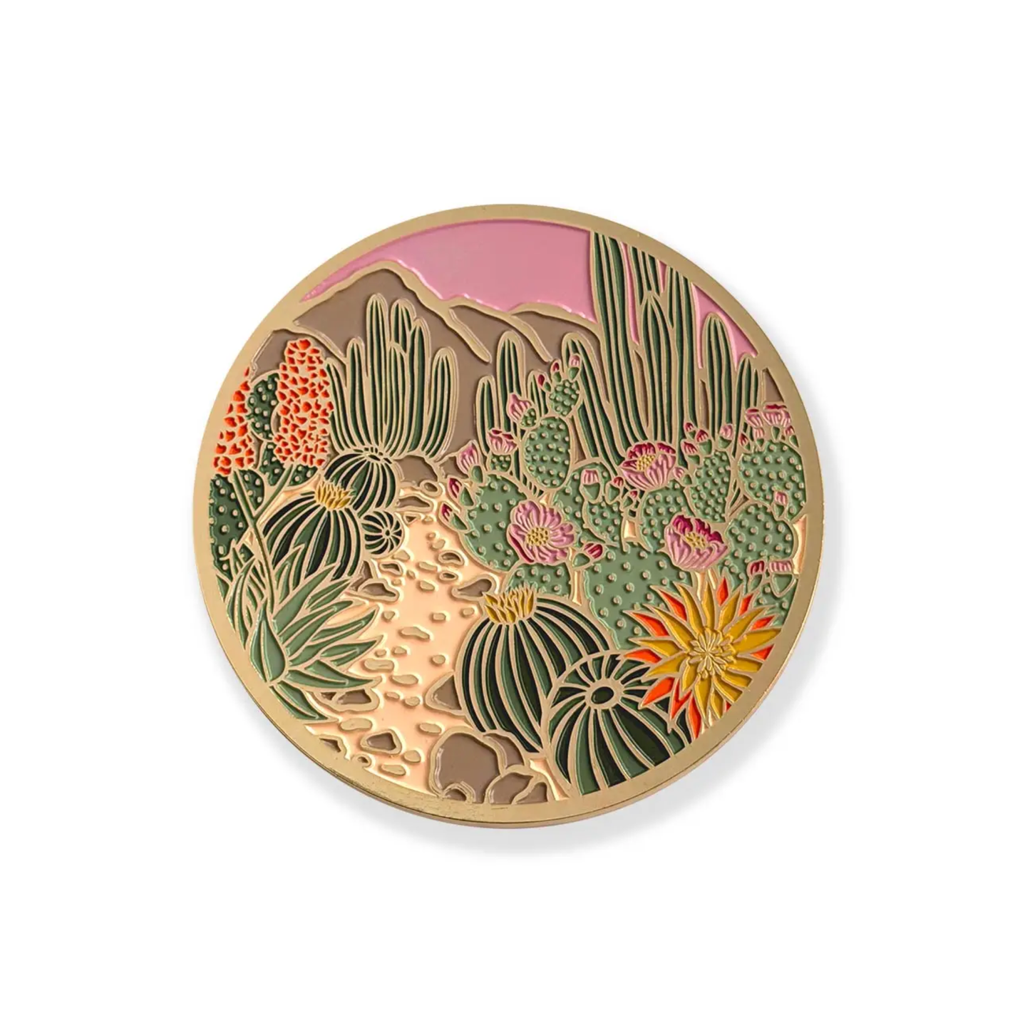 a gold plated coaster with a blooming desert design featuring cacti, mountains and a pink sky against a white background