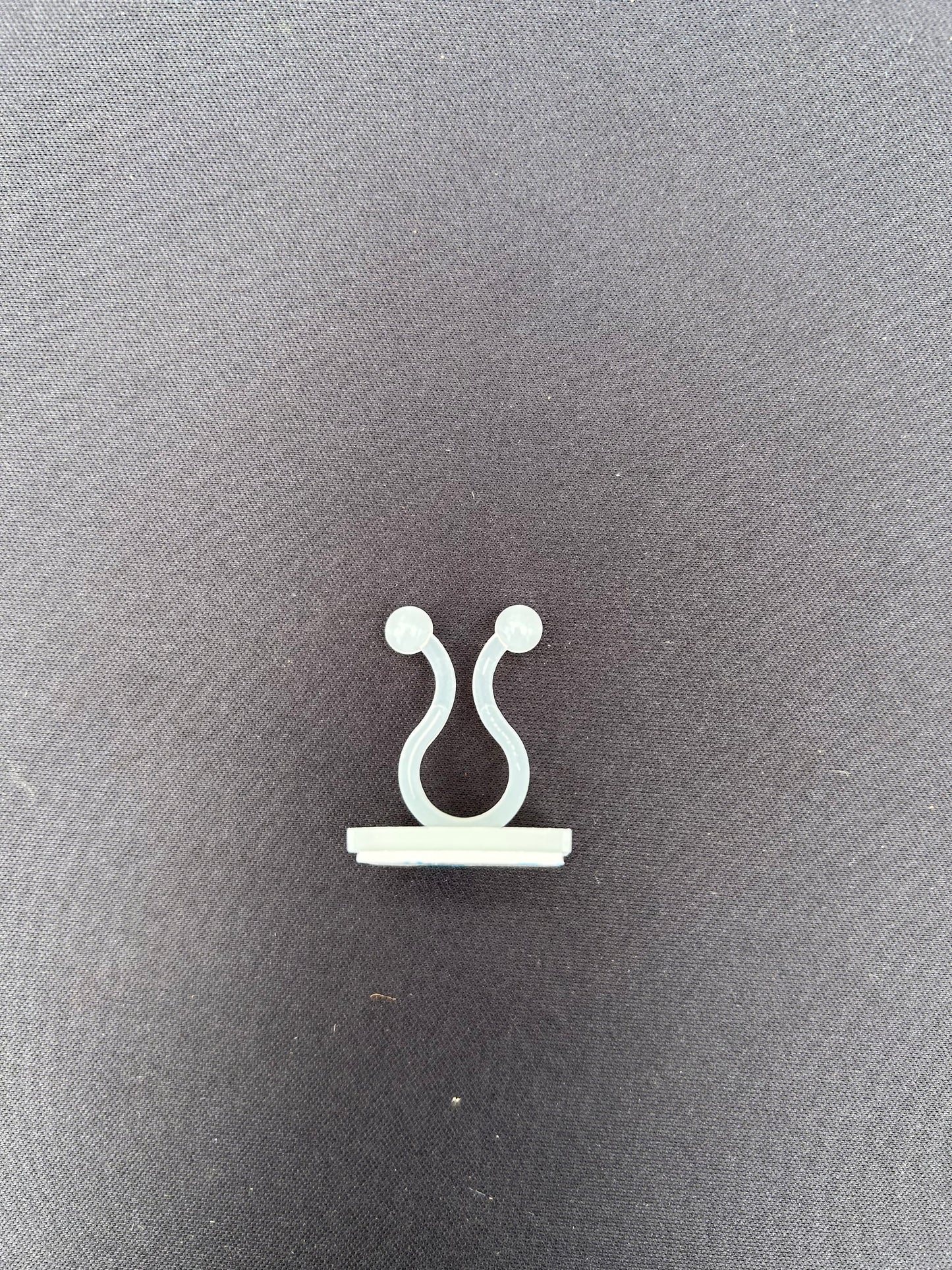 a clear u shaped clip resting on a black surface