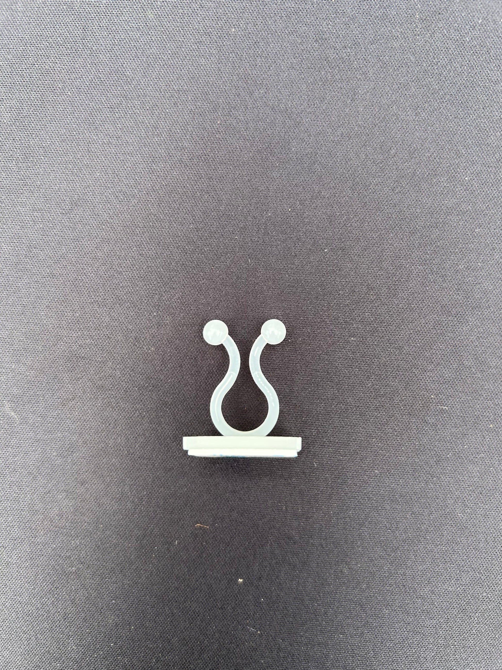 a clear u shaped clip resting on a black surface