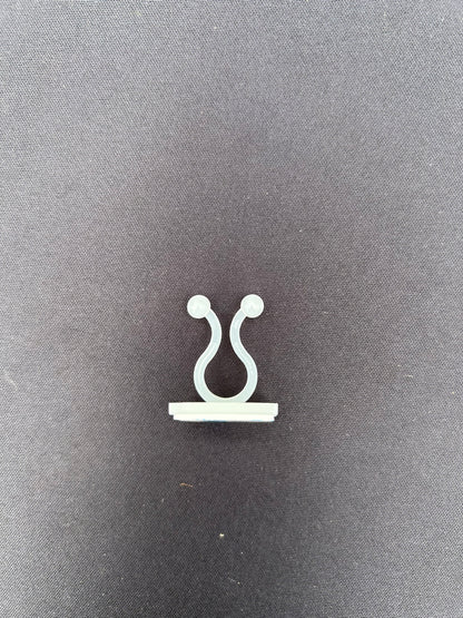 a clear u shaped clip resting on a black surface