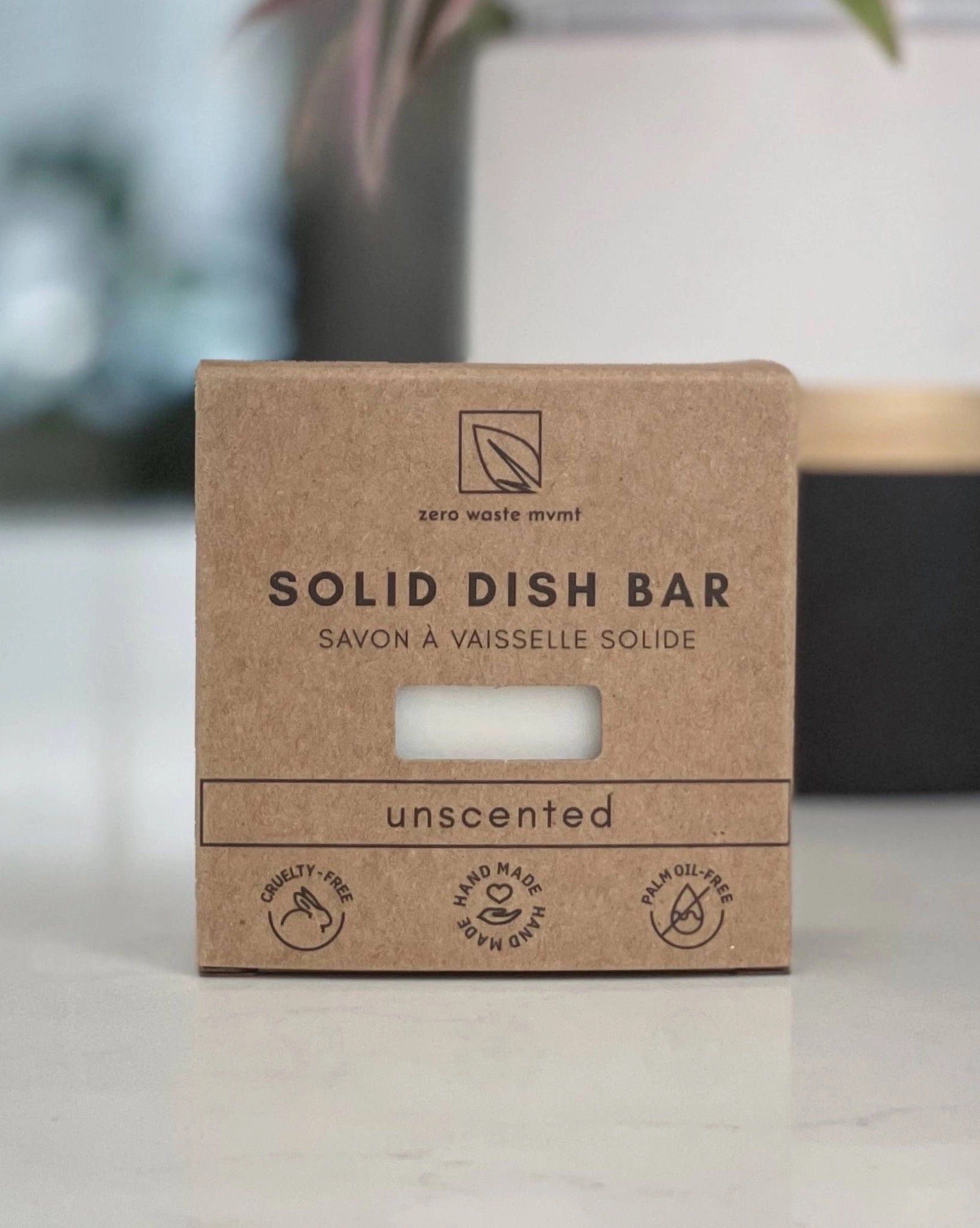 a natural solid dish bar unscented soap in a cardboard package resting on a white surface