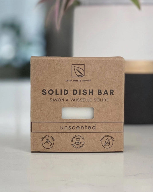 a natural solid dish bar unscented soap in a cardboard package resting on a white surface