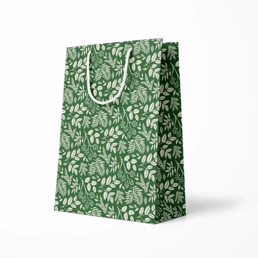 Green gift bag with white leaf pattern on a white background