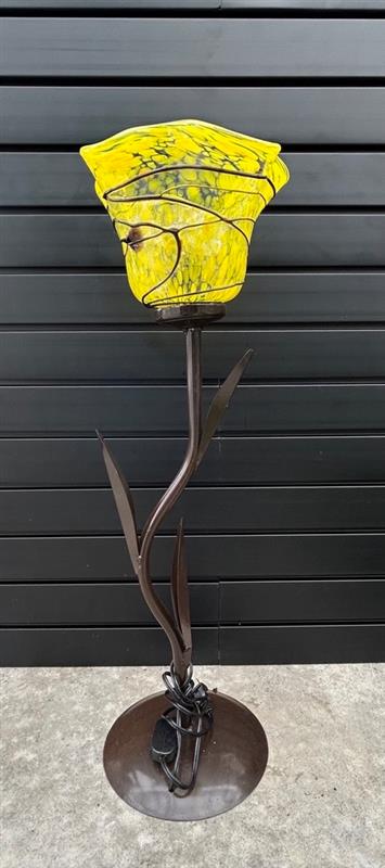 A modern style glass lamp with a yellow tinted top and a brown metal base, displayed against a black background.