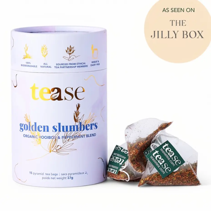 a pale purple tin labeled tease golden slumbers organic peppermint tea blend with three tea bags next to it with a white package