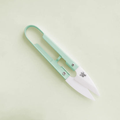 a pair of green plant snips against a green background