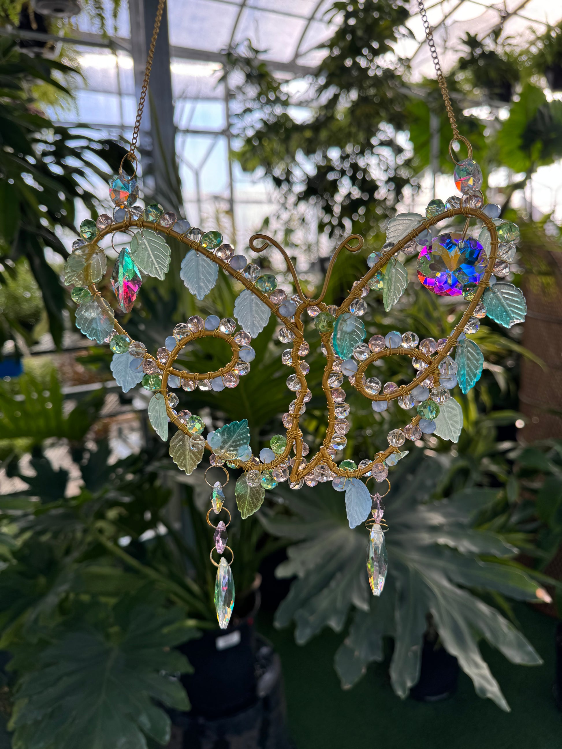 decorative crystal sun catcher in the shape of a butterfly with leaves and dangling sparkling crystals
